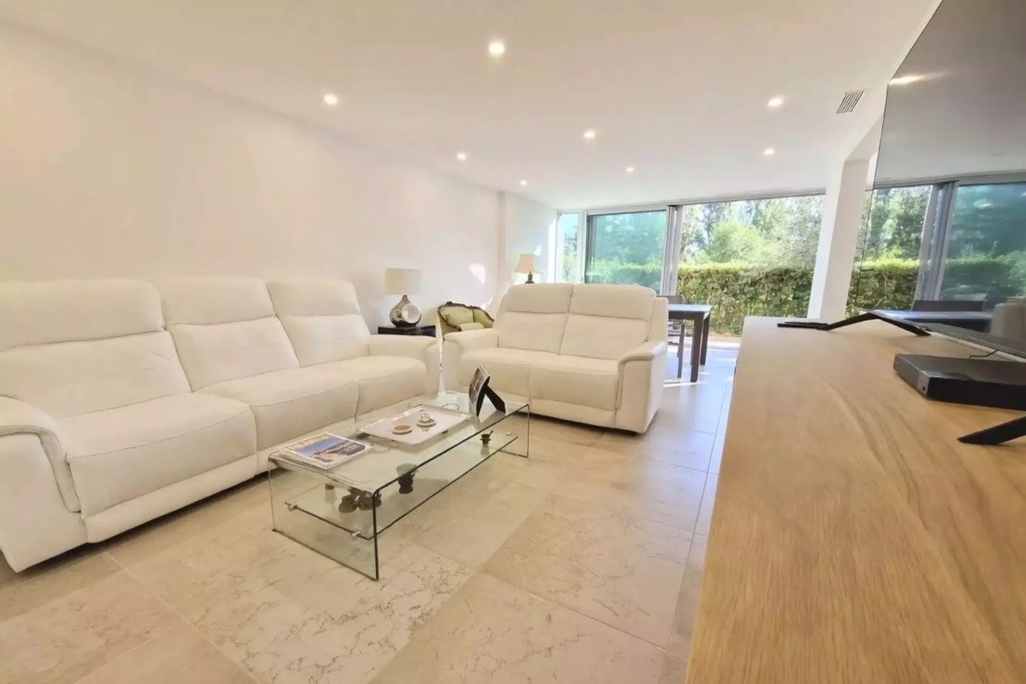 Séjour avec salon blanc et vue sur l'extérieur